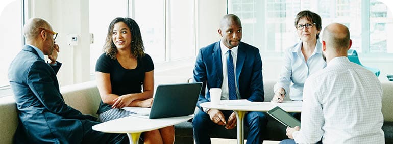 Group of businesspeople in discussion during informal project meeting in office