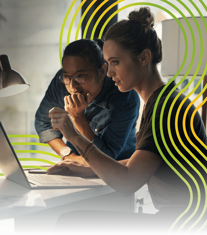 Shot of two young coworkers using a laptop during a late night at work