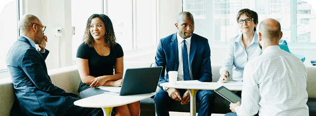 Group of businesspeople in discussion during informal project meeting in office